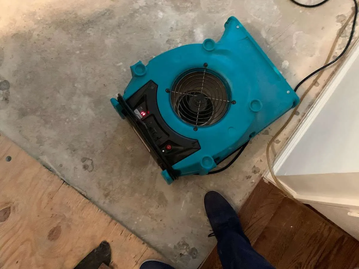 Air mover drying subfloor during Commercial Water Damage Restoration in Crosspointe